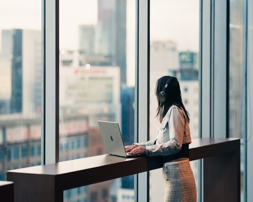 Woman working on a laptop in a brightly lit modern office
