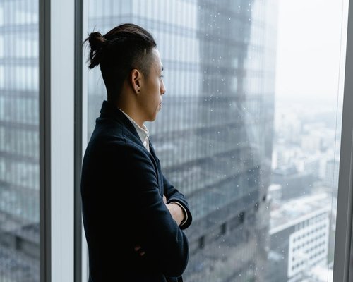 A person looking out of an office window over the city